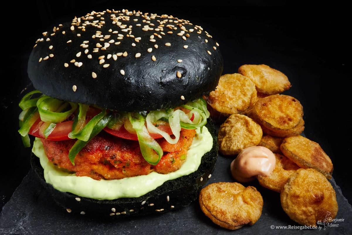 Lachsburger auf schwarzem Bun mit fried Pickles